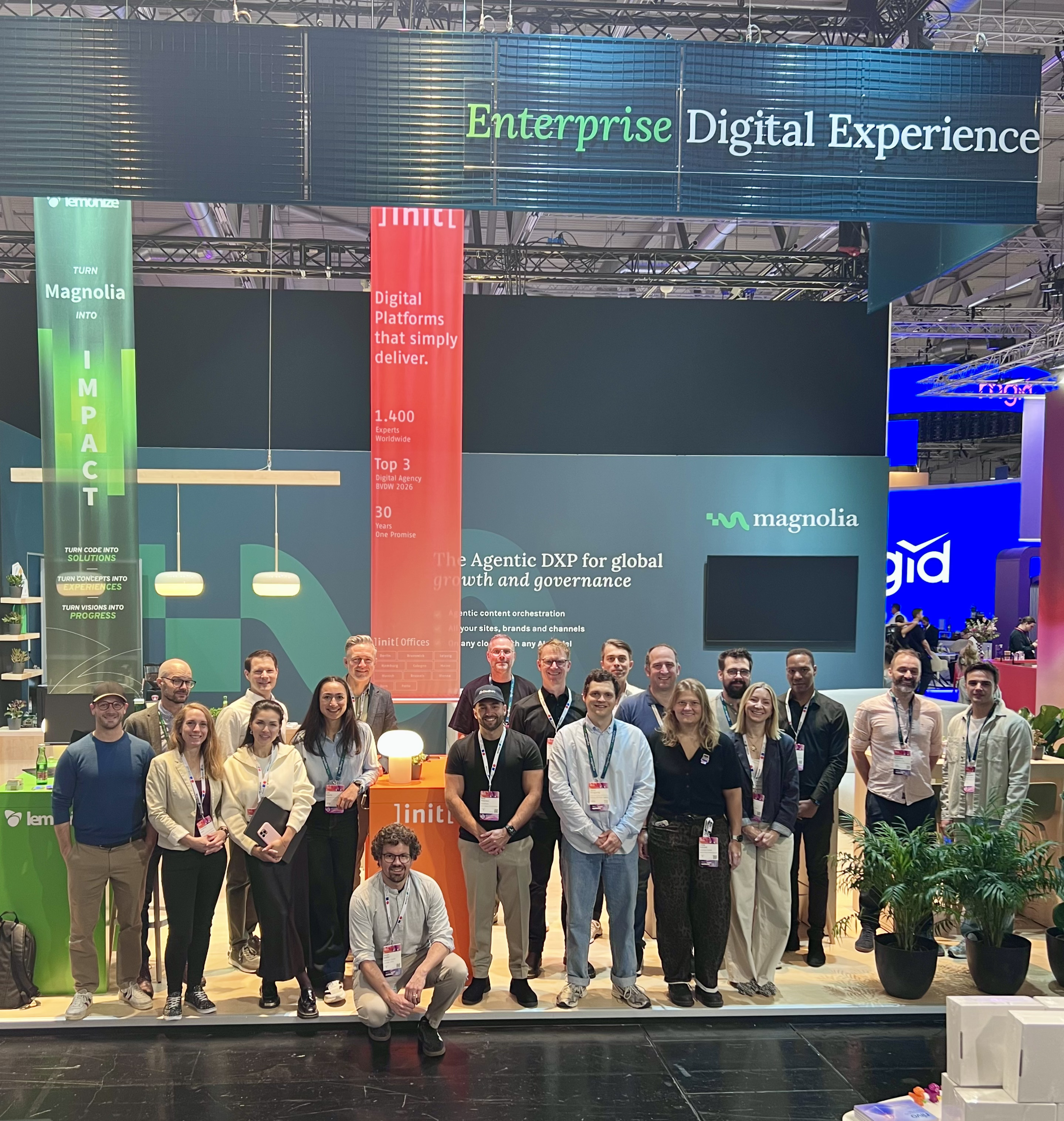 The Magnolia team gathered in front of the main booth backdrop displaying 'The Agentic DXP for global growth and governance'