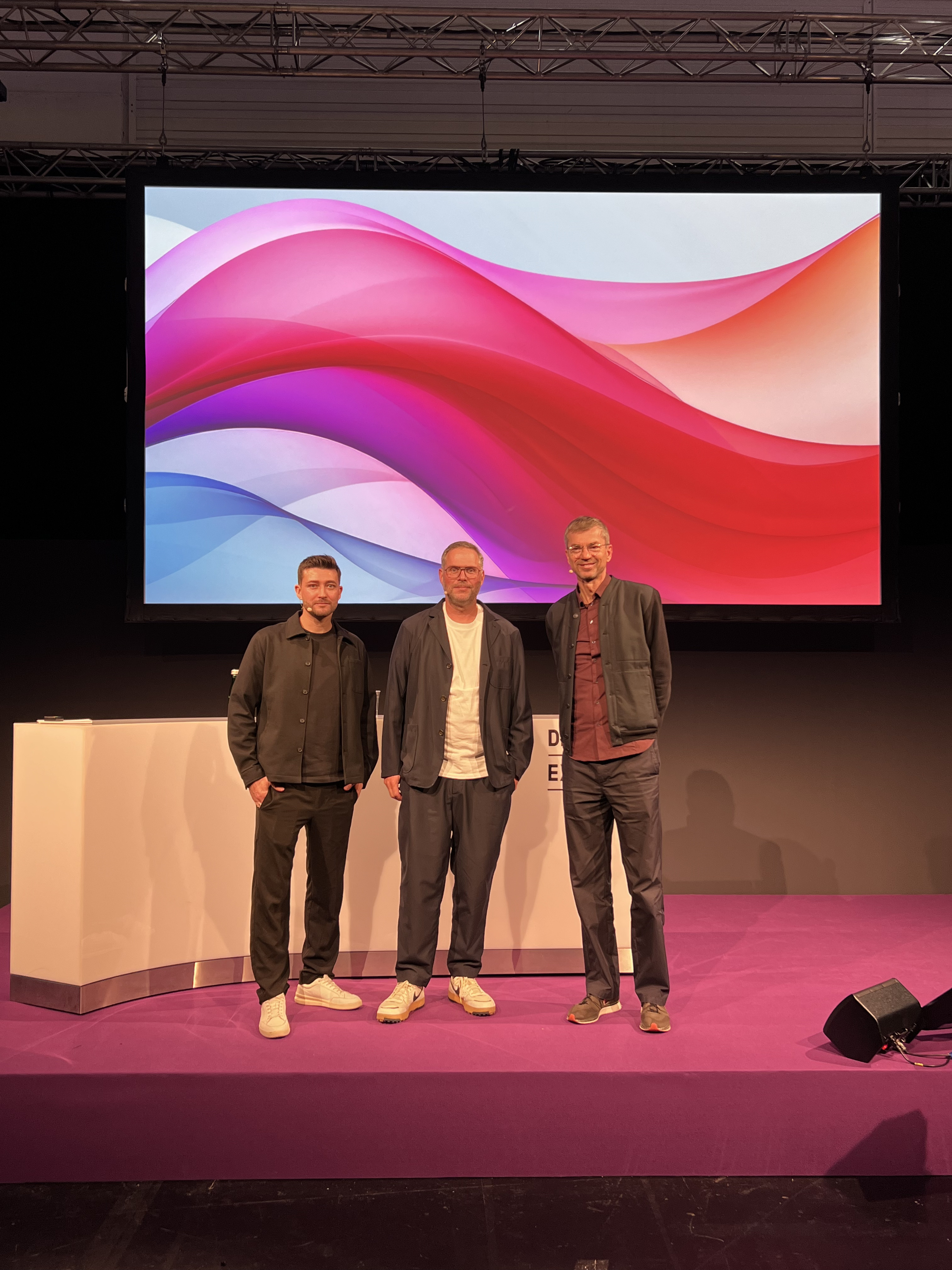 Speakers Sebastian Stang, Michael Weiss, and Klaus Cloppenburg on stage